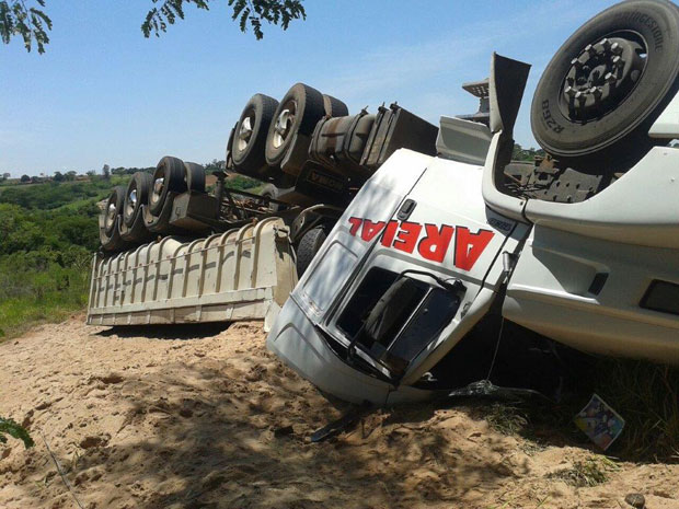 Carreta carregada com areia tomba em vicinal e fica com os pneus pra cima