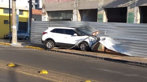 Caminhão cruza sinal vermelho e atinge veículo que vai parar em cima da calçada