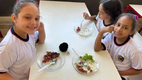 Crianças almoçam o tradicional churrasco na escola em Queiroz